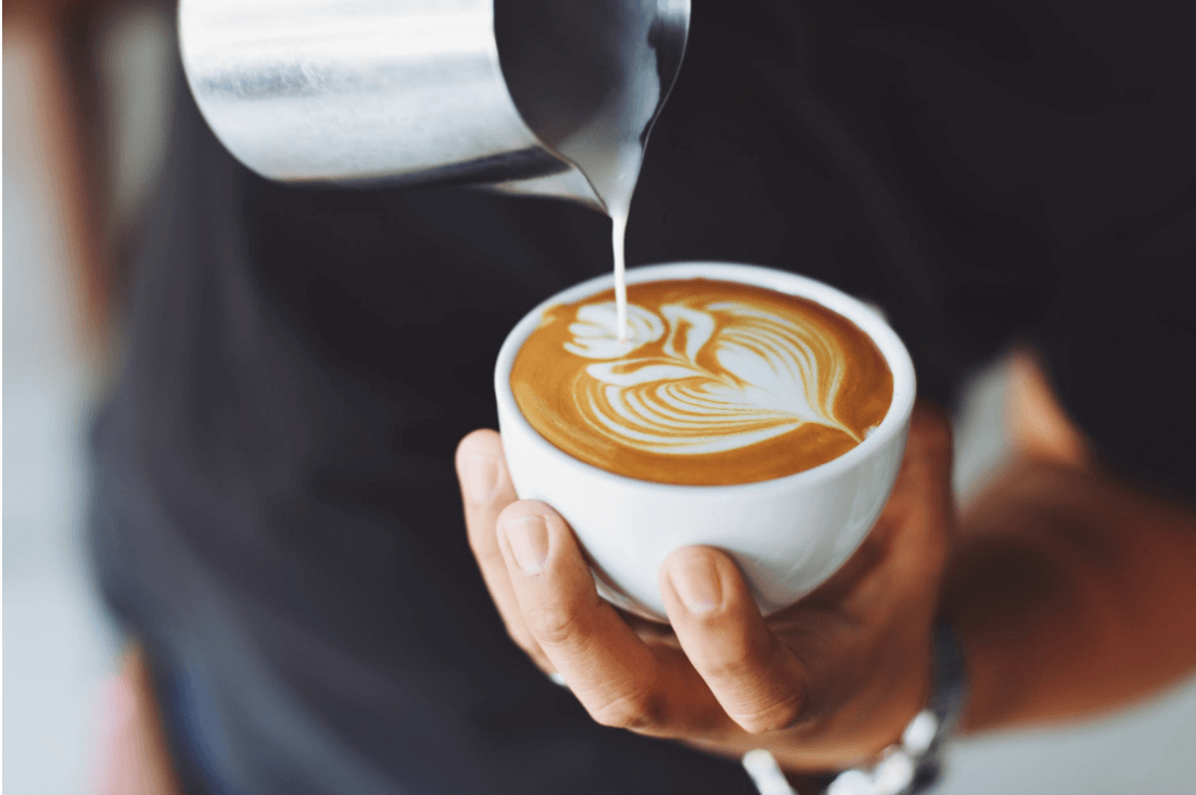 Barista making a latte with flower art