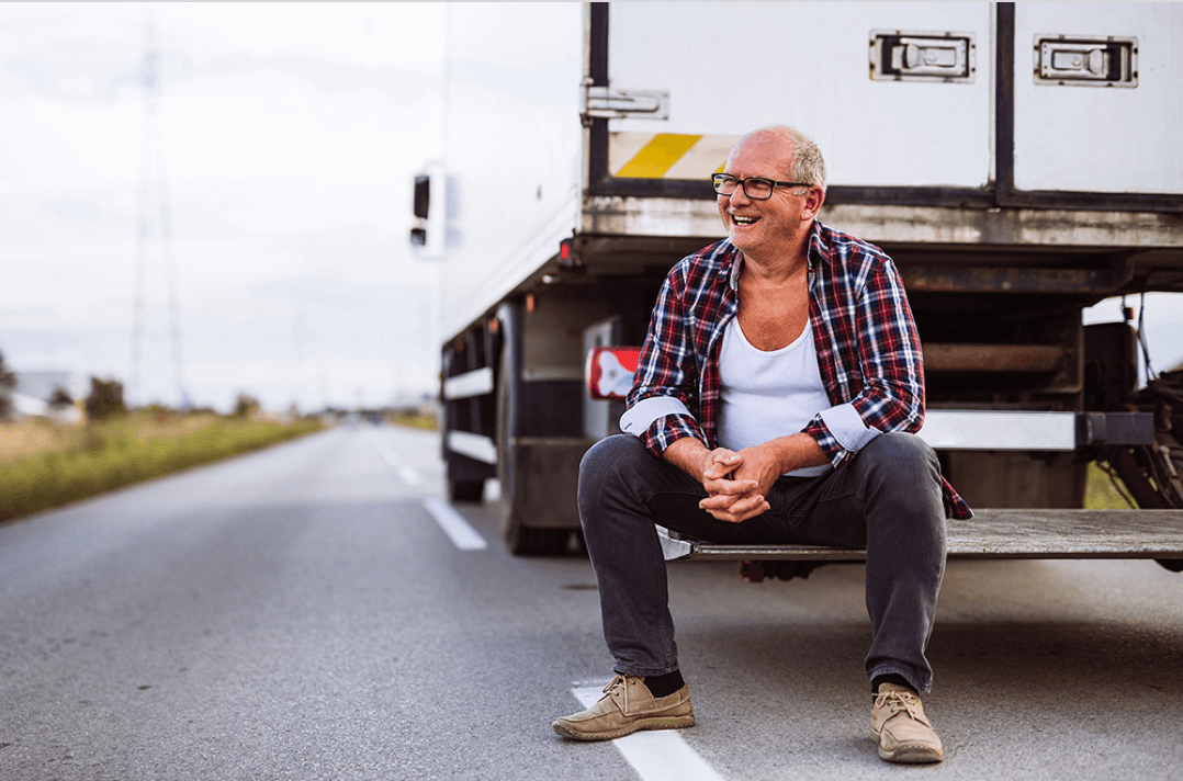 Smiling trucker sitting on delivery truck